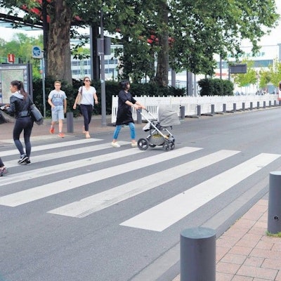 Das Foto zeigt Passanten, die die Stationsstraße überqueren