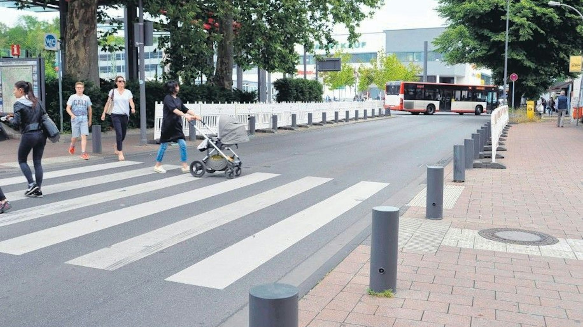 Das Foto zeigt Passanten, die die Stationsstraße überqueren