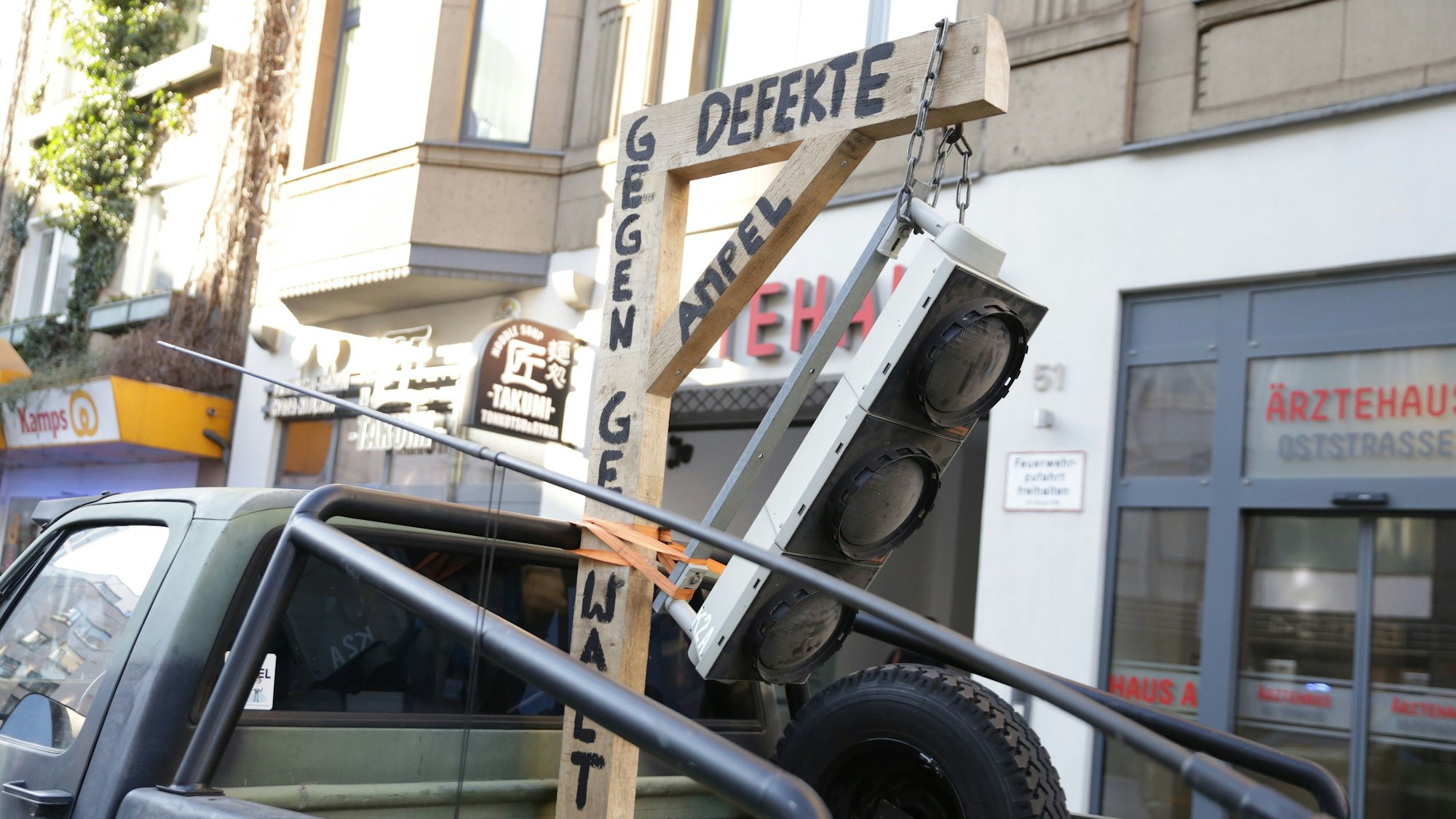 Auf der Ladefläche eines Lkws hängt eine Ampel an einem Galgen.