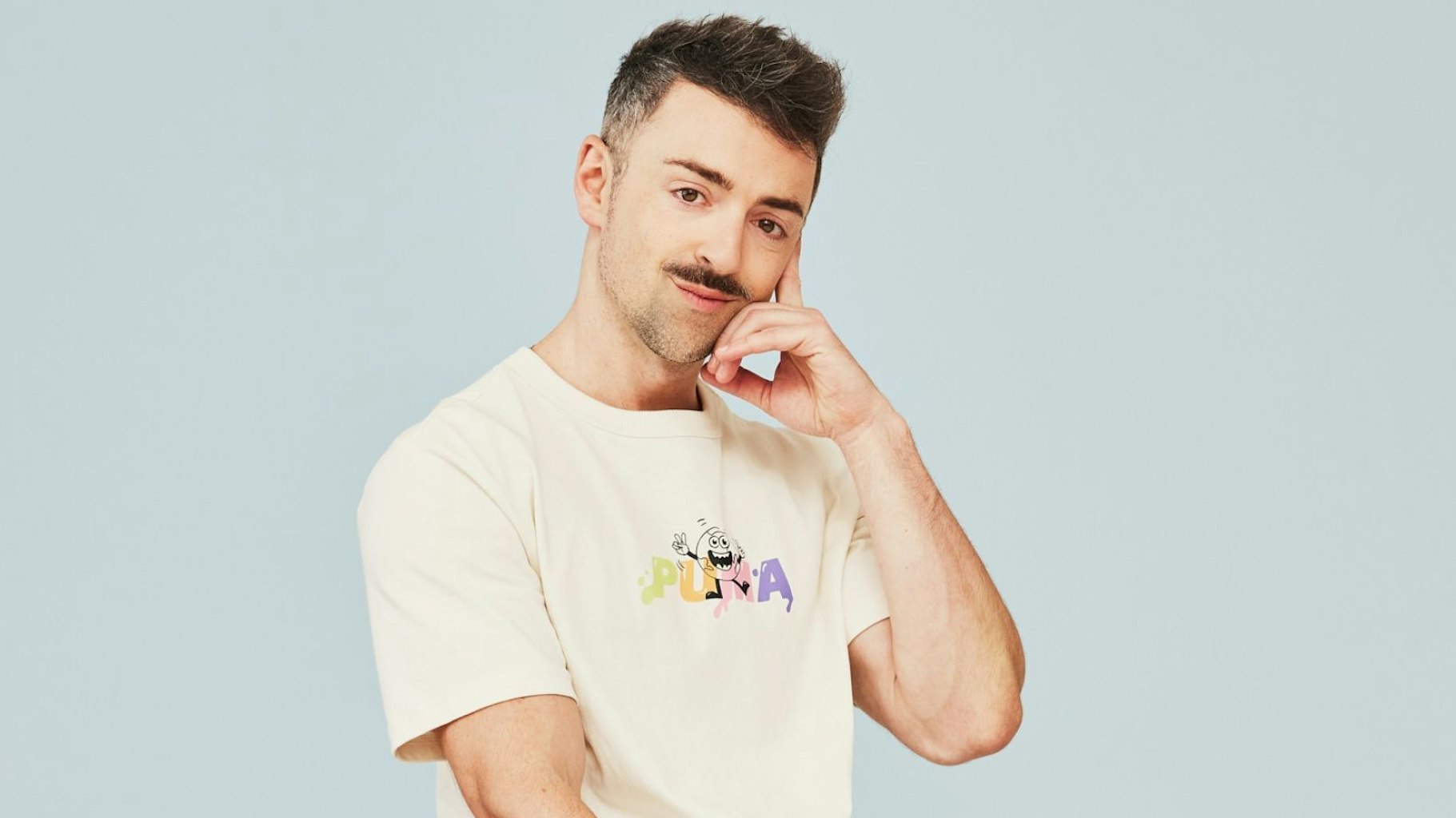 US-Stand-up-Comedian Matteo Lane posiert im weißen T-Shirt.