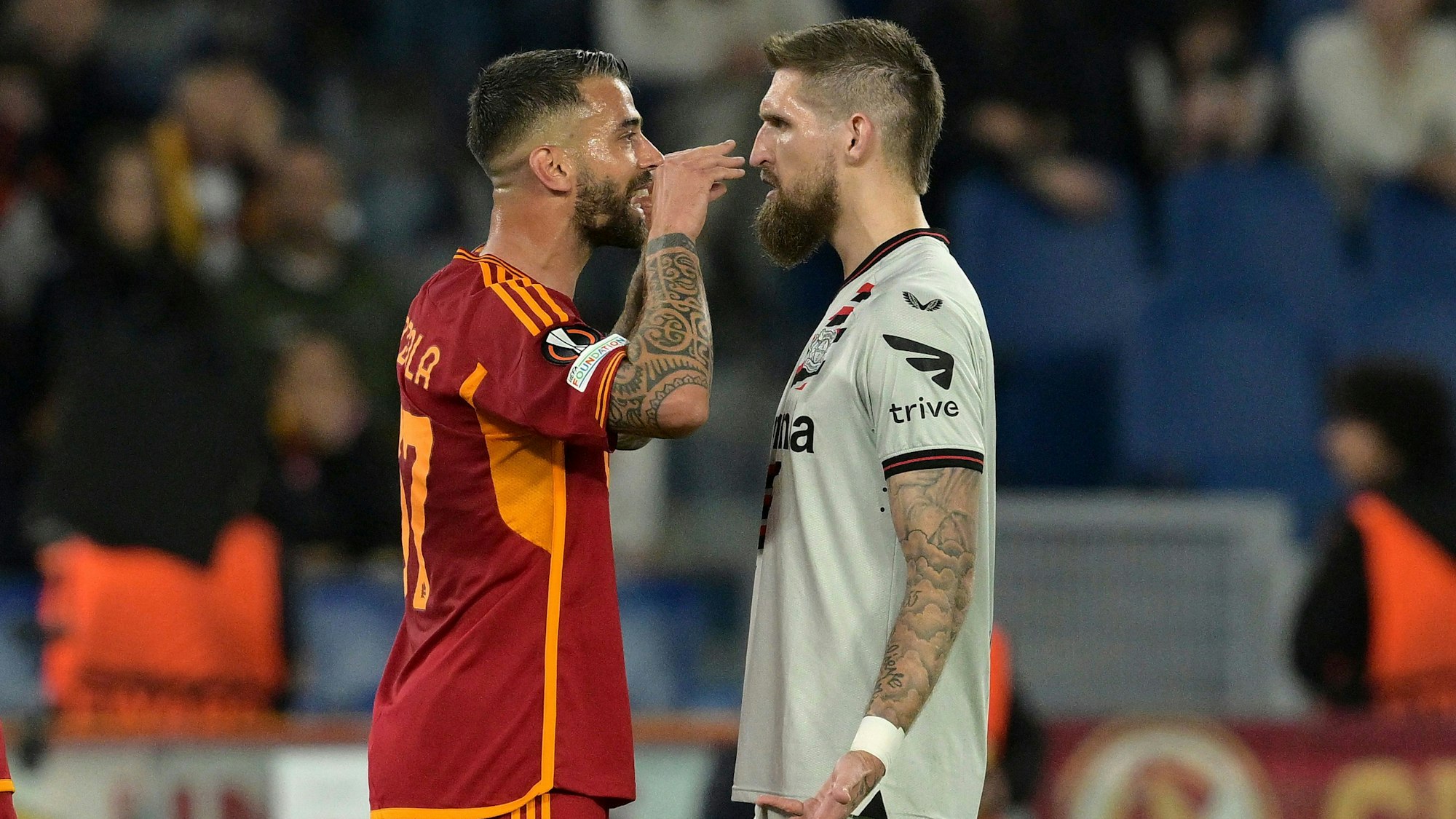 Roma's Leonardo Spinazzola, left, and Leverkusen's Robert Andrich exchange words during the Europa League semifinal first leg soccer match between Roma and Bayer Leverkusen at Rome's Olympic Stadium in Rome, Italy, Thursday, May 2, 2024. (Alfredo Falcone/LaPresse via AP)