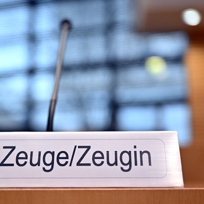 Ein Schild mit der Aufschrift „Zeuge/Zeugin“ steht auf einem Tisch im Landtag.