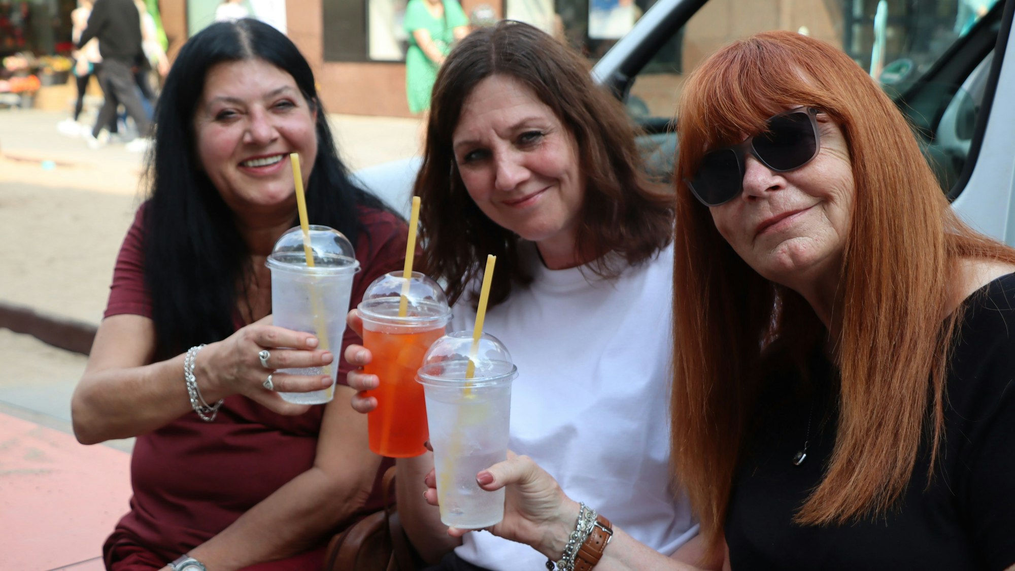 Zu sehen sind drei Besucherinnen, die einen Cocktail trinken.