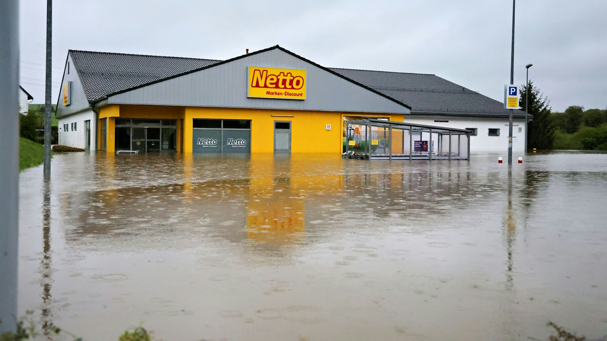 Der Parkplatz des Marktes hat sich in einen See verwandelt. Das Wasser hat die Eingangstür eingedrückt und den Markt geflutet.