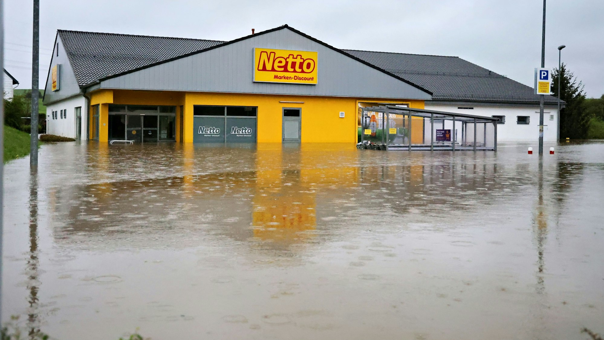 Der Netto Markt in Dahlem und der davor liegende Parkplatz stehen unter Wasser.