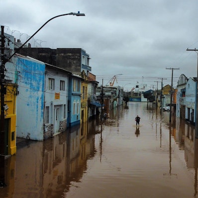 Ein Mann watet in Porto Alegre im brasilianischen Bundesstaat Rio Grande do Sul durch ein von schweren Regenfällen überschwemmtes Gebiet.