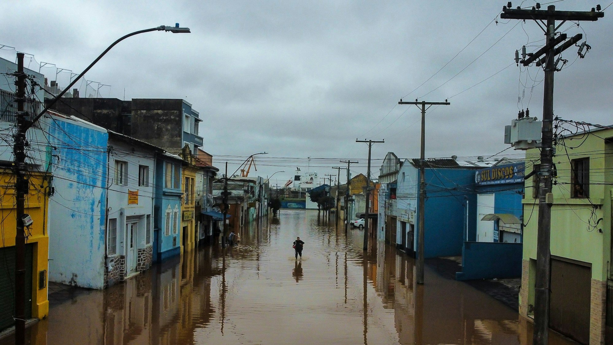 Ein Mann watet in Porto Alegre im brasilianischen Bundesstaat Rio Grande do Sul durch ein von schweren Regenfällen überschwemmtes Gebiet.