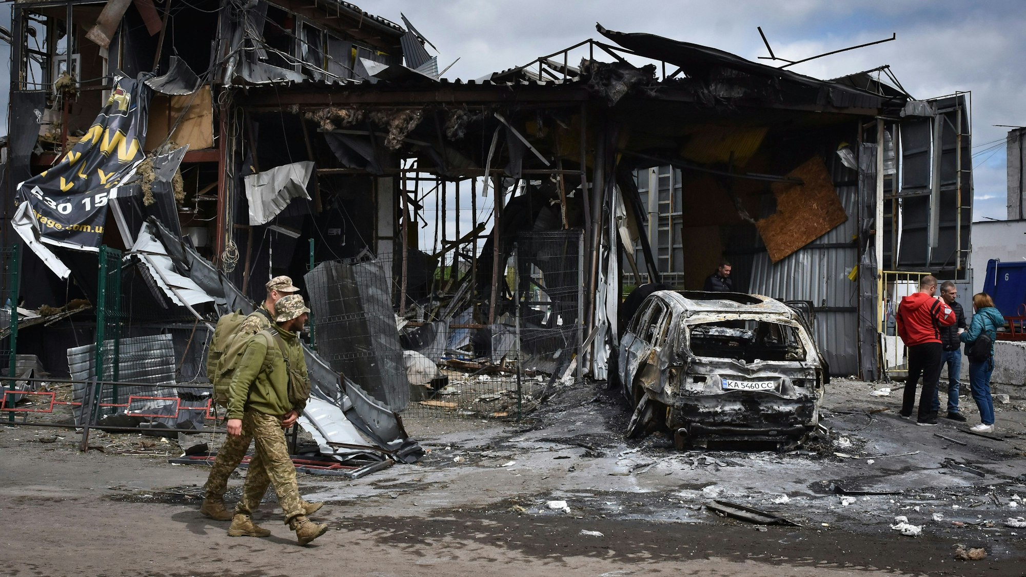 Dnipro im April 2024: Ukrainische Soldaten passieren ein durch einen russischen Angriff beschädigtes Gebäude.