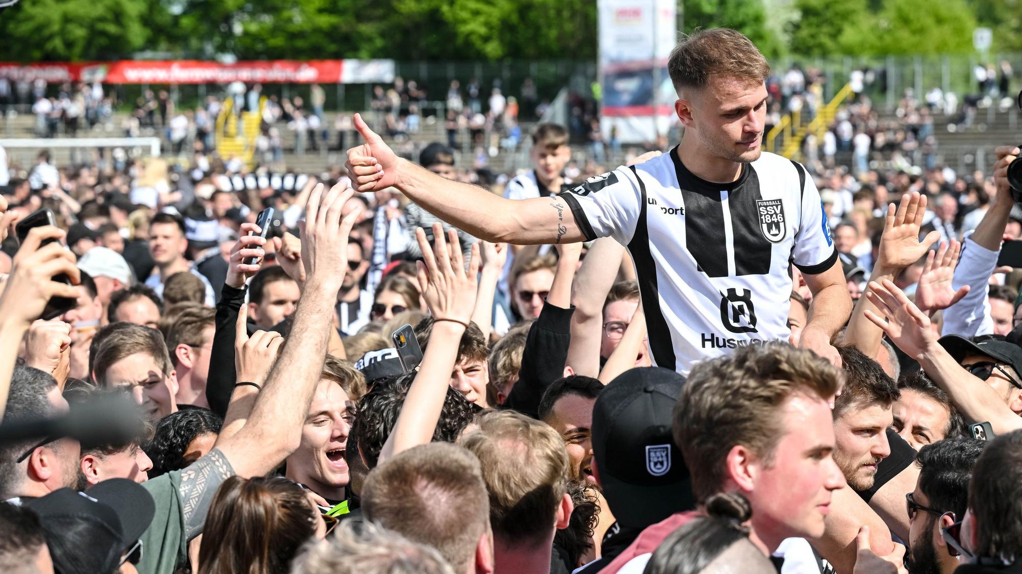 04.05.2024, Baden-Württemberg, Ulm: Fußball: 3 Liga, SSV Ulm 1846 Fussball - FC Viktoria Köln im Donaustadion. Ulms Leo Scienza feiert mit den Fans den Aufstieg. Foto: Harry Langer/DeFodi Images/dpa - WICHTIGER HINWEIS: Gemäß den Vorgaben der DFL Deutsche Fußball Liga bzw. des DFB Deutscher Fußball-Bund ist es untersagt, in dem Stadion und/oder vom Spiel angefertigte Fotoaufnahmen in Form von Sequenzbildern und/oder videoähnlichen Fotostrecken zu verwerten bzw. verwerten zu lassen. +++ dpa-Bildfunk +++