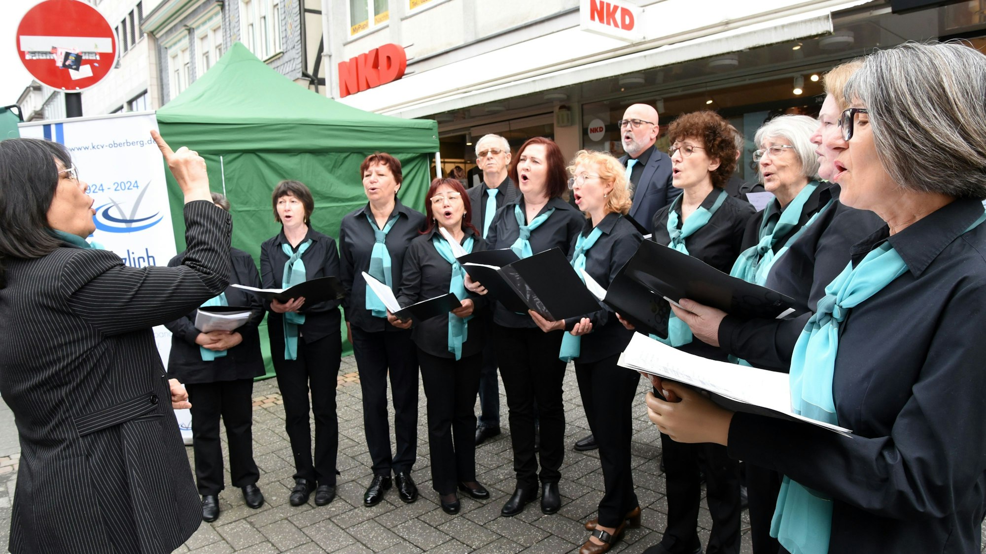 Ein Frauenchor singt vor dem Ladengeschäft NKD.
