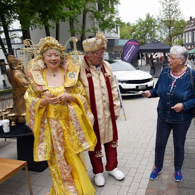 Ein Paar in chinesischer Festtracht wird von Passanten bewundert.