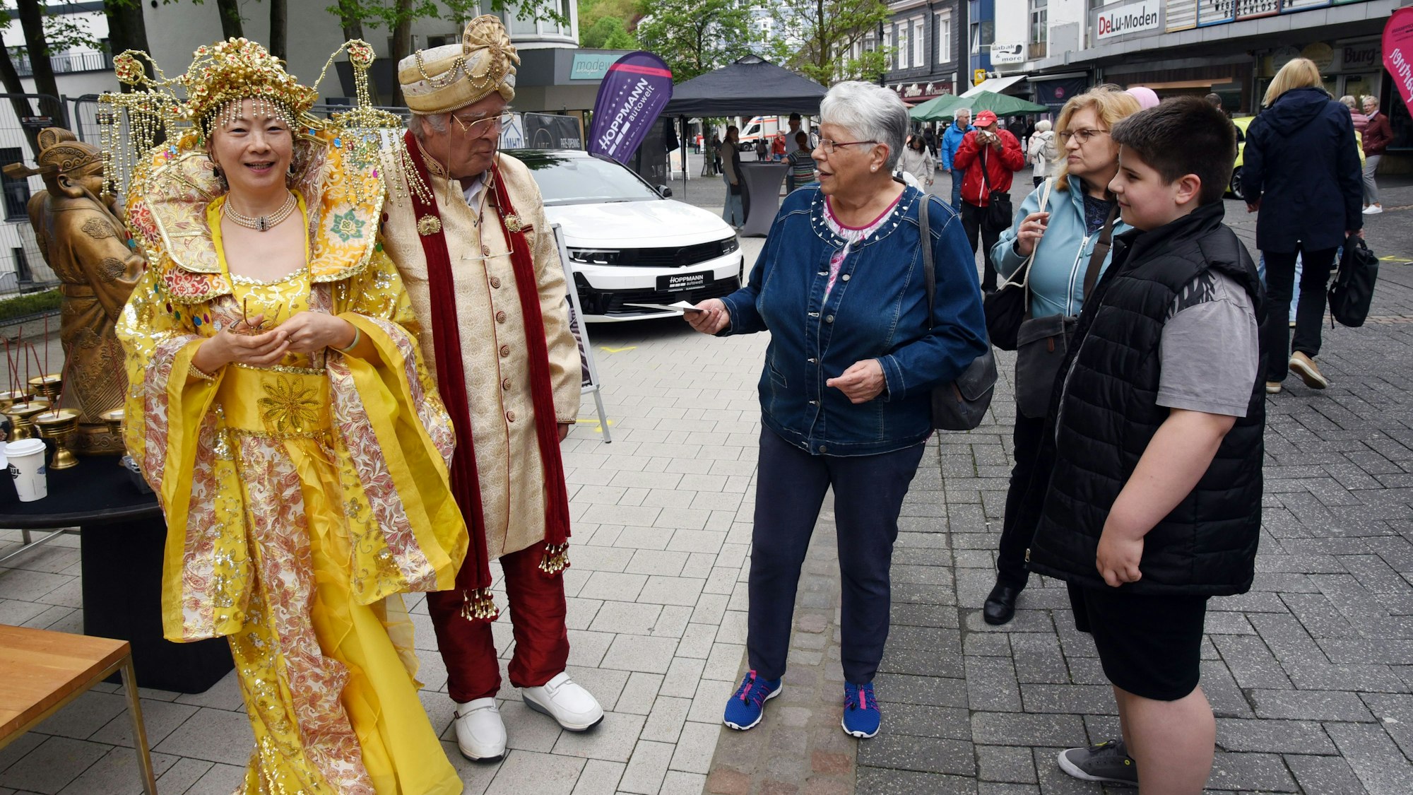 Ein Paar in chinesischer Festtracht wird von Passanten bewundert.