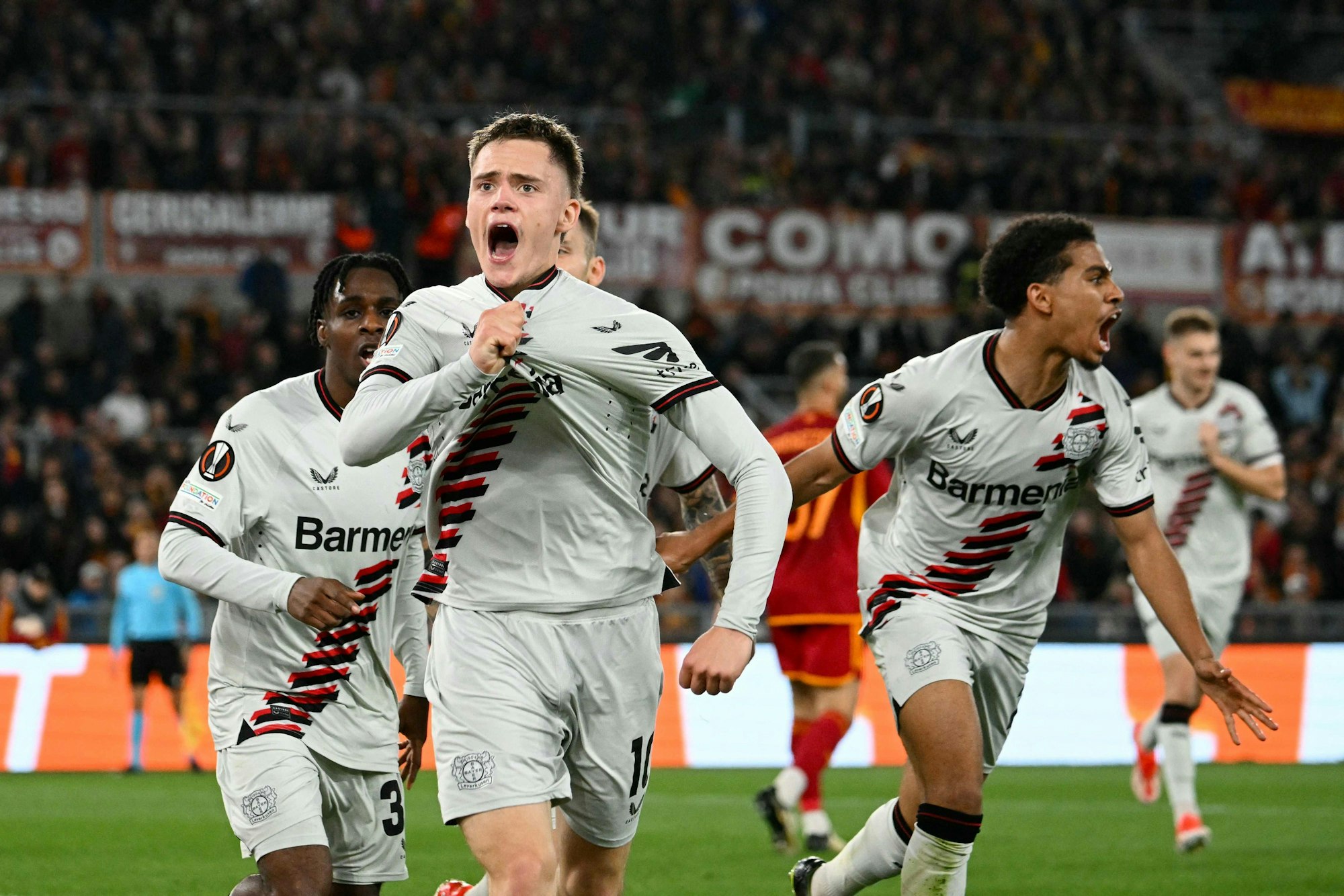 TOPSHOT - Bayer Leverkusen's German midfielder #10 Florian Wirtz celebrates with teammates after scoring his team first goal during the UEFA Europa League semi final first leg football match between AS Roma and Bayer Leverkusen at the Olympic stadium on May 2, 2024 in Rome. (Photo by Alberto PIZZOLI / AFP)