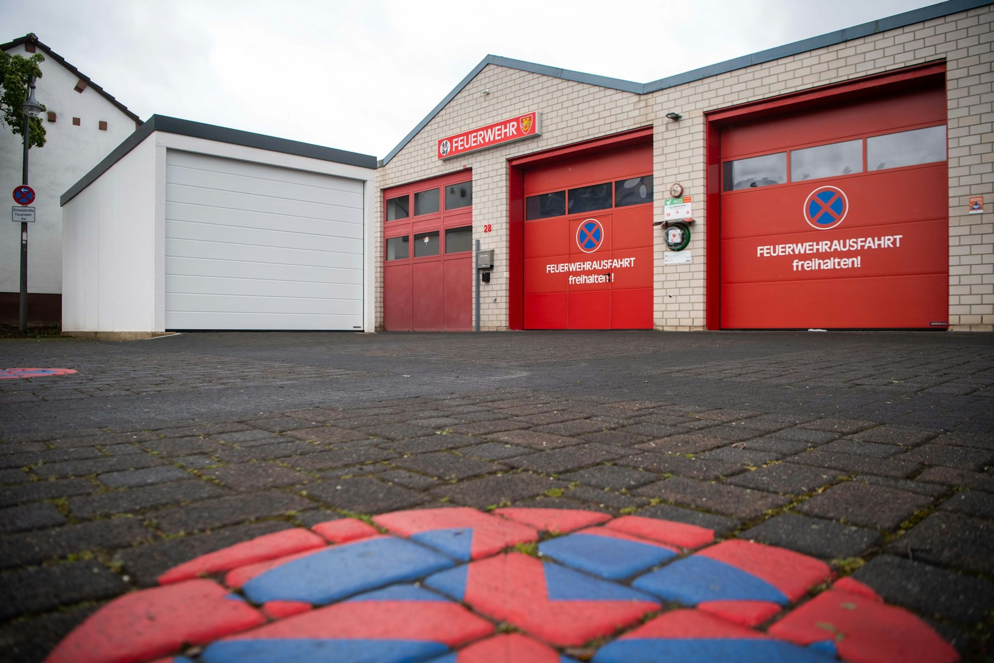 Neben den Toren des Kuchenheimer Gerätehauses ist eine Garage zu sehen.