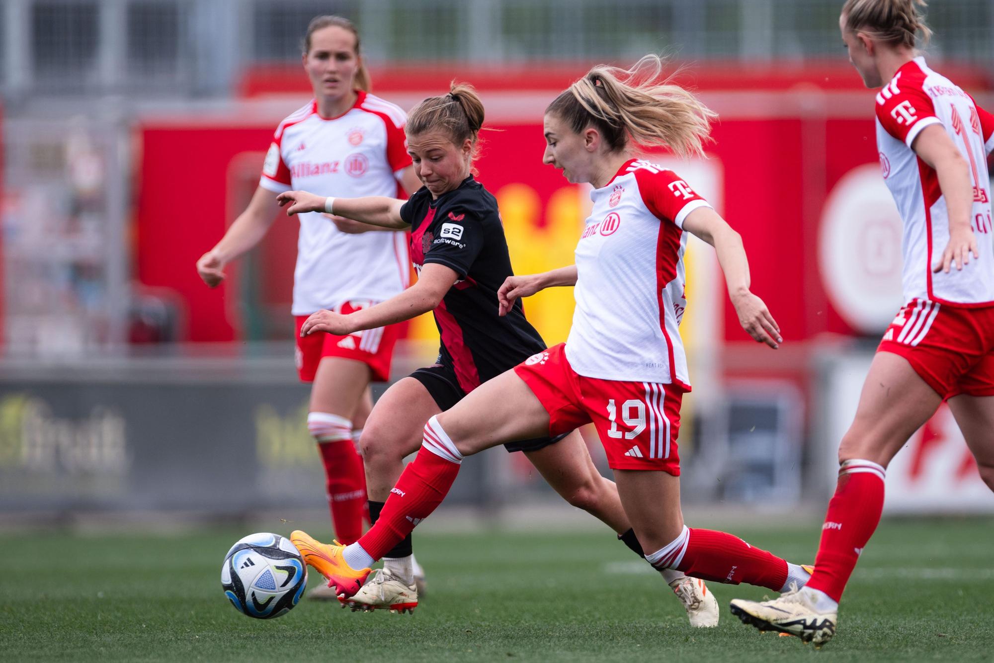 04.05.2024, Nordrhein-Westfalen, Leverkusen: Fußball, Frauen: Bundesliga, Bayer Leverkusen - Bayern München, 20. Spieltag, Ulrich-Haberland-Stadion. Bayern Münchens Katharina Naschenweng (r) undLeverkusens Kristin Kögel kämpfen um den Ball. Foto: Marius Becker/dpa - WICHTIGER HINWEIS: Gemäß den Vorgaben der DFL Deutsche Fußball Liga bzw. des DFB Deutscher Fußball-Bund ist es untersagt, in dem Stadion und/oder vom Spiel angefertigte Fotoaufnahmen in Form von Sequenzbildern und/oder videoähnlichen Fotostrecken zu verwerten bzw. verwerten zu lassen. +++ dpa-Bildfunk +++