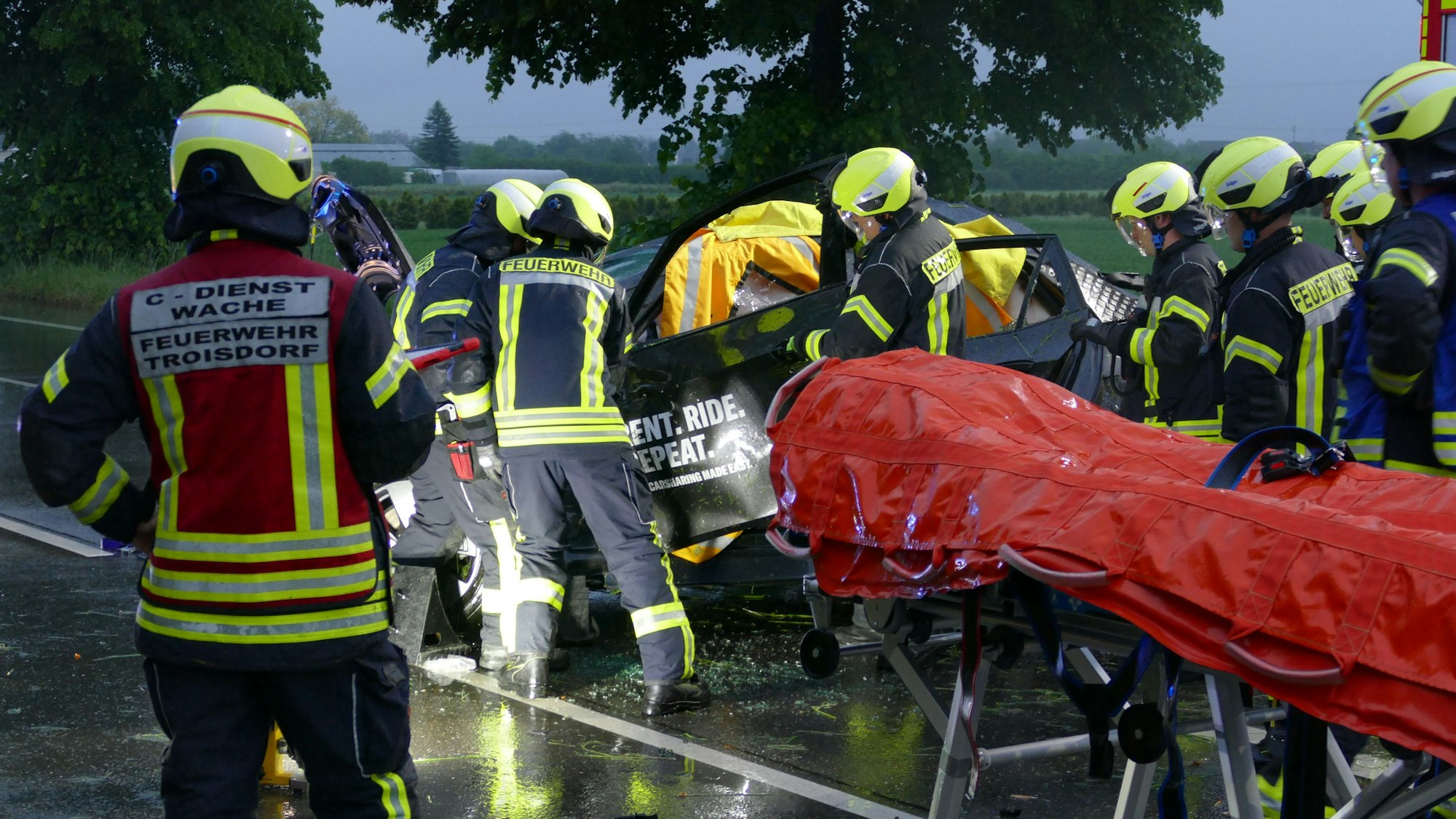 Feuerwehrleute schneiden eine Tür an einem Auto weg.