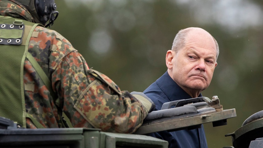 Bundeskanzler Olaf Scholz (SPD) fährt auf einem gepanzerten Militärfahrzeug.
