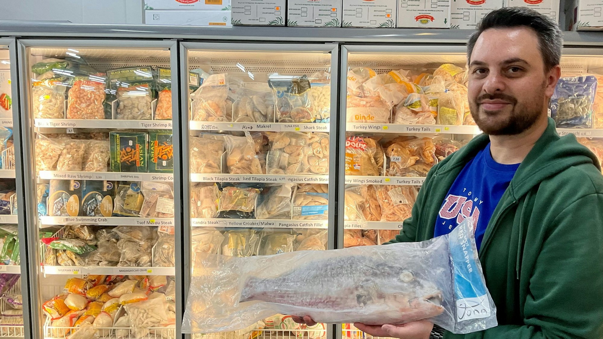 Mann mit einem eingepackten, tiefgefrorenen Fisch