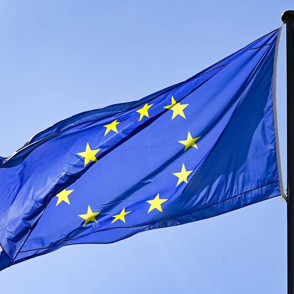 Eine Europaflagge weht vor blauem Himmel.