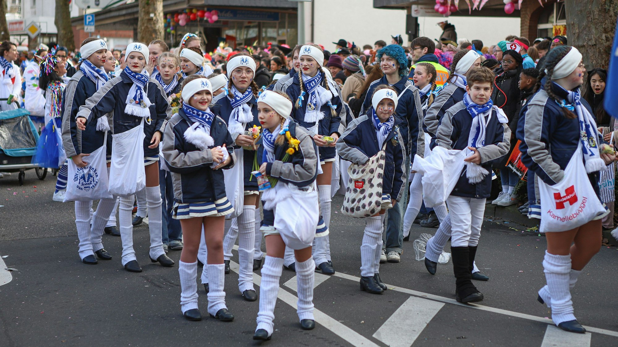 Junge Karnevalisten im Opladener Zug verteilen Kamelle.