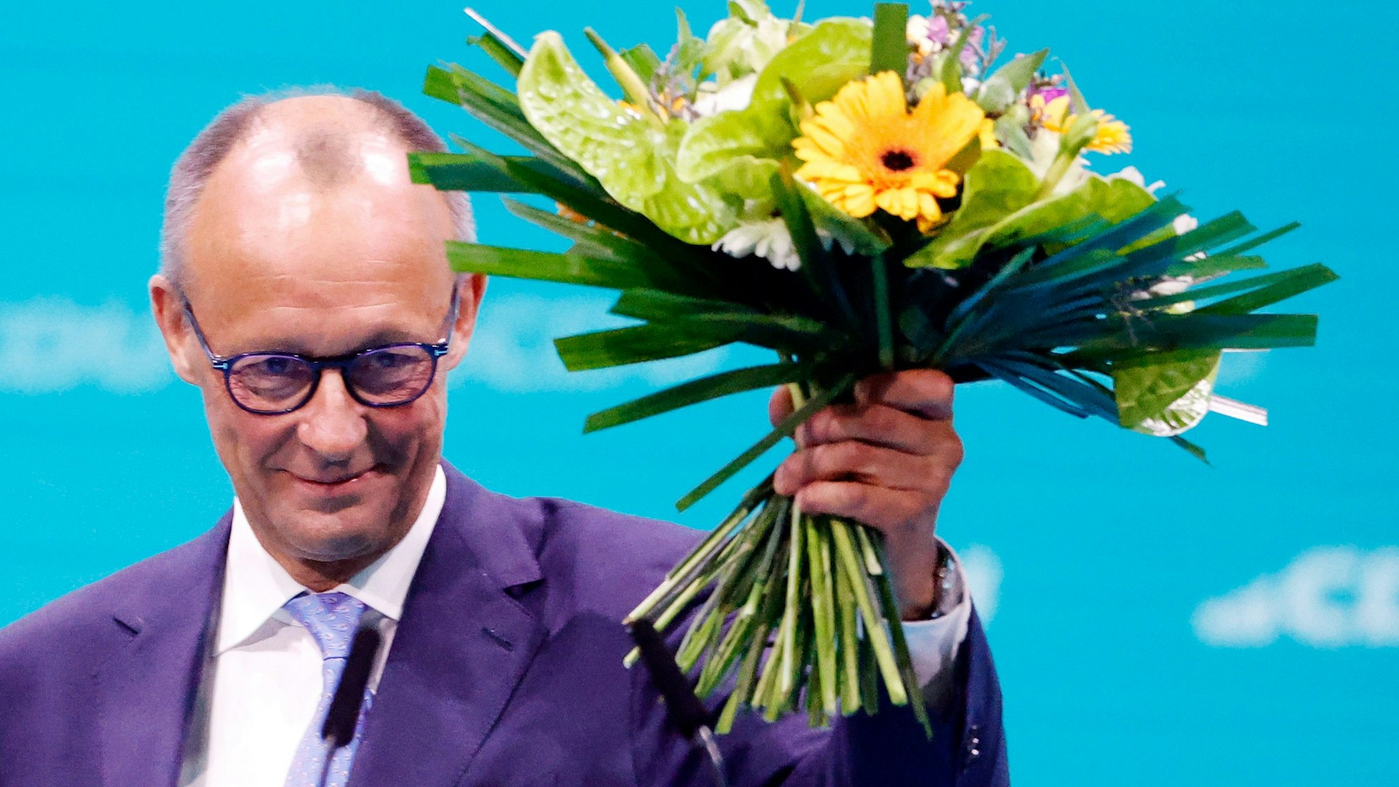 Friedrich Merz, CDU-Bundesvorsitzender, hält seinen Blumenstrauss nach der Wahl zum Bundesvorsitzenden beim CDU-Bundesparteitag hoch.
