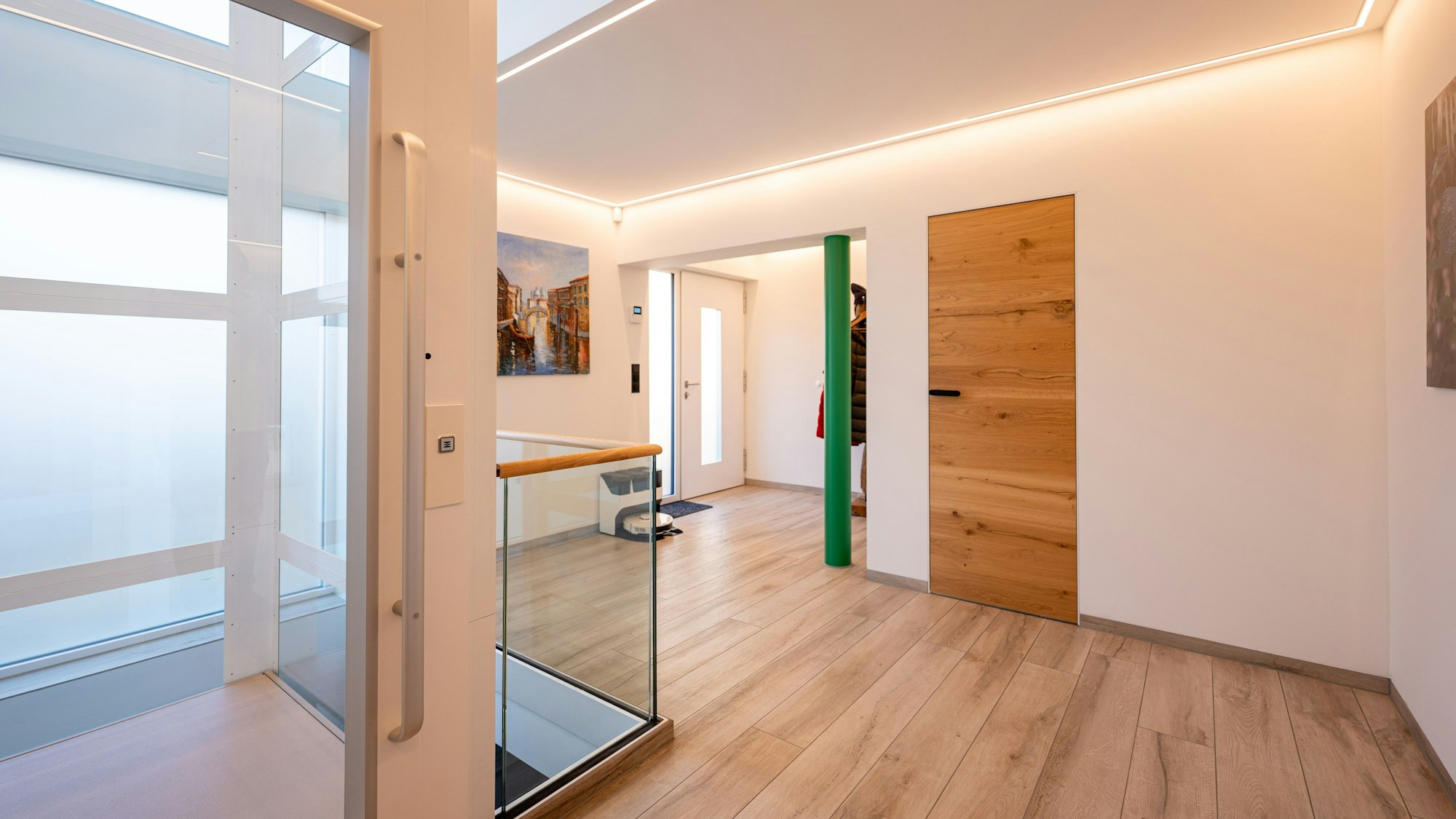 Im Eingangsbereich der Immobilie befindet sich ein gläserner Fahrstuhl. Die Böden sind mit Parkett ausgelegt.