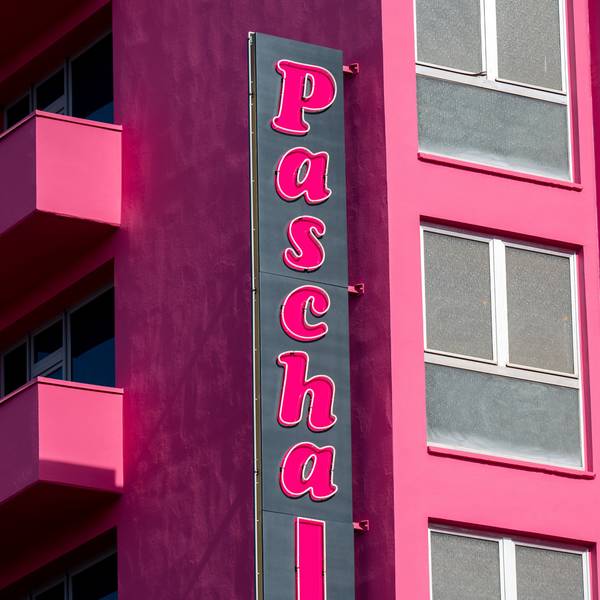Das Bordell ist von der Seite zu sehen mit Schriftzug und pinkfarbener Fassade.