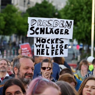 Ein Demonstrant hält bei einer Solidaritätskundgebung in Berlin ein Plakat mit der Aufschrift „Dresden Schläger – Höckes willige Helfer“. Sowohl in der Hauptstadt als auch in Dresden versammelten sich am Sonntag Menschen aus Solidarität mit dem angegriffenen SPD-Politiker Matthias Ecke und einem Wahlhelfer.