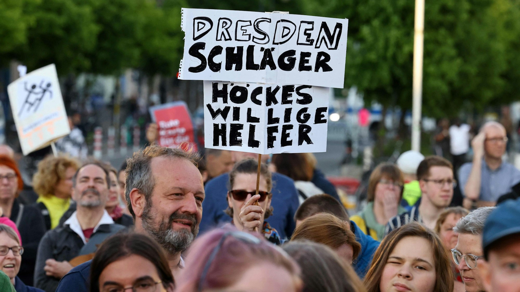 Ein Demonstrant hält bei einer Solidaritätskundgebung in Berlin ein Plakat mit der Aufschrift „Dresden Schläger – Höckes willige Helfer“. Sowohl in der Hauptstadt als auch in Dresden versammelten sich am Sonntag Menschen aus Solidarität mit dem angegriffenen SPD-Politiker Matthias Ecke und einem Wahlhelfer.