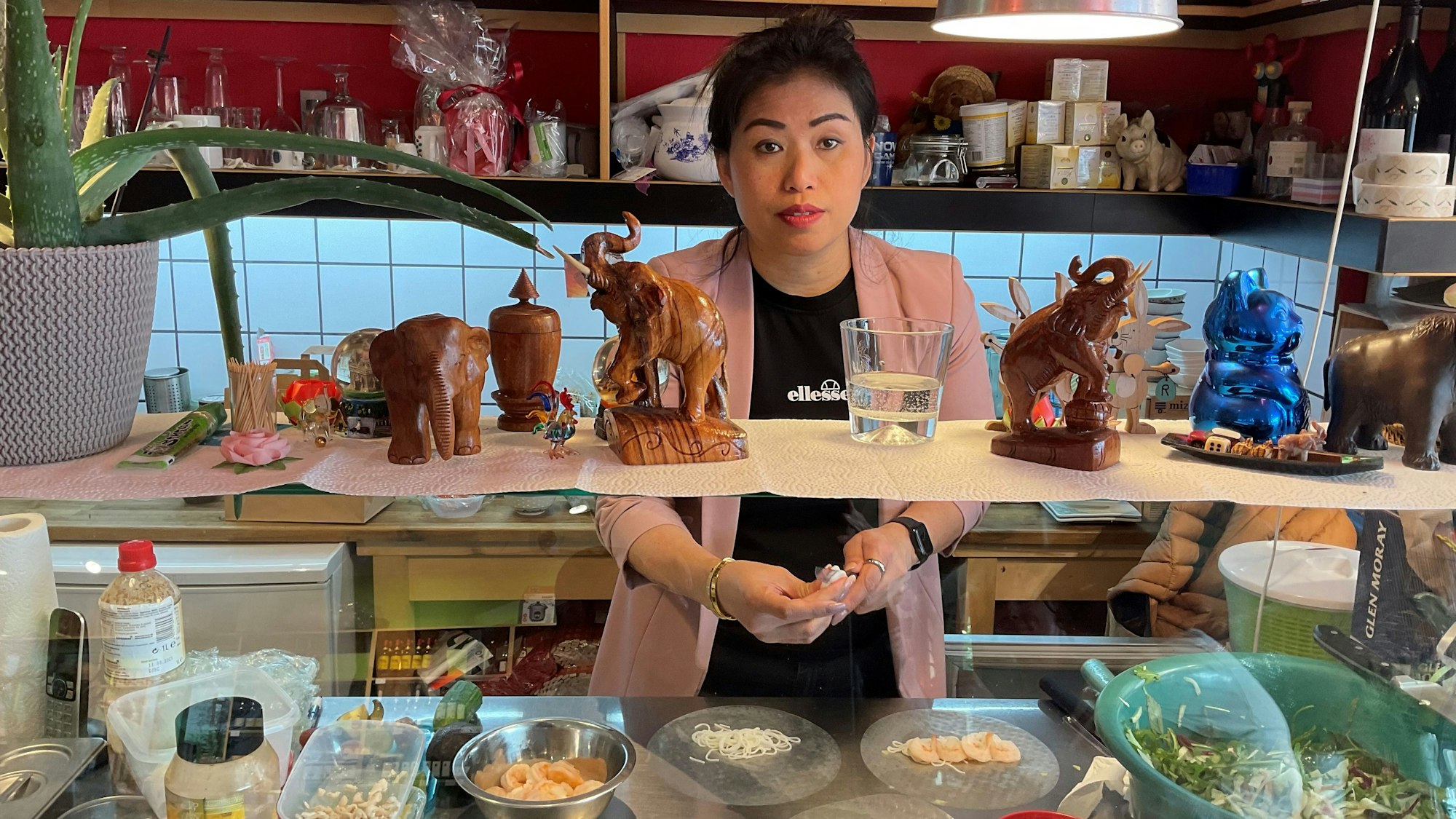 Frau hinter Theke eines asiatischen Geschäfts