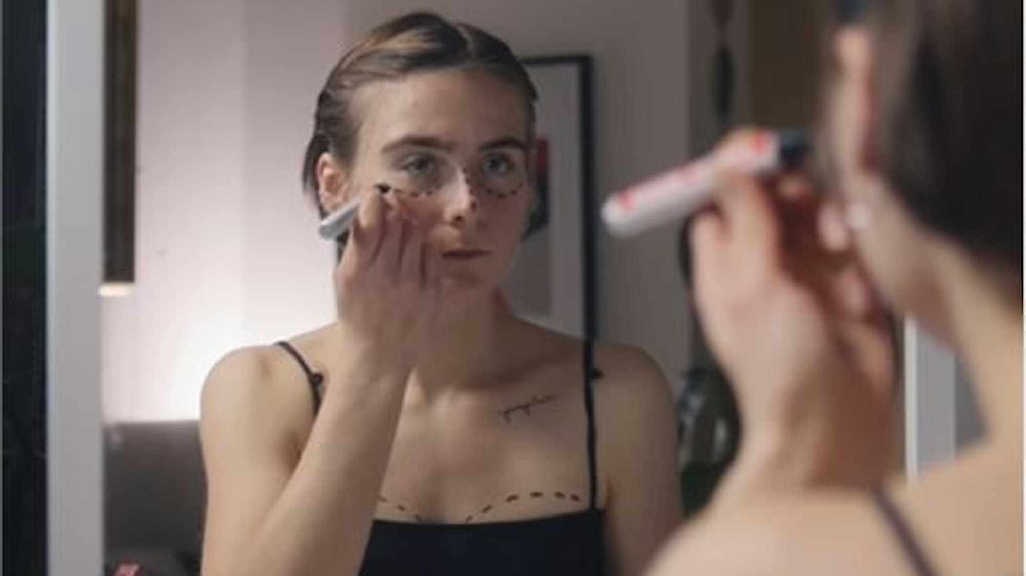 Eine junge Frau malt sich OP-Markierungen auf die Haut, nachdem sie auf Instagram Frauen mit Körpern, die dem Schönheitsideal entsprechen, gesehen hat.