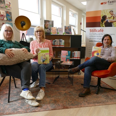 Drei Menschen sitzen auf Stühlen