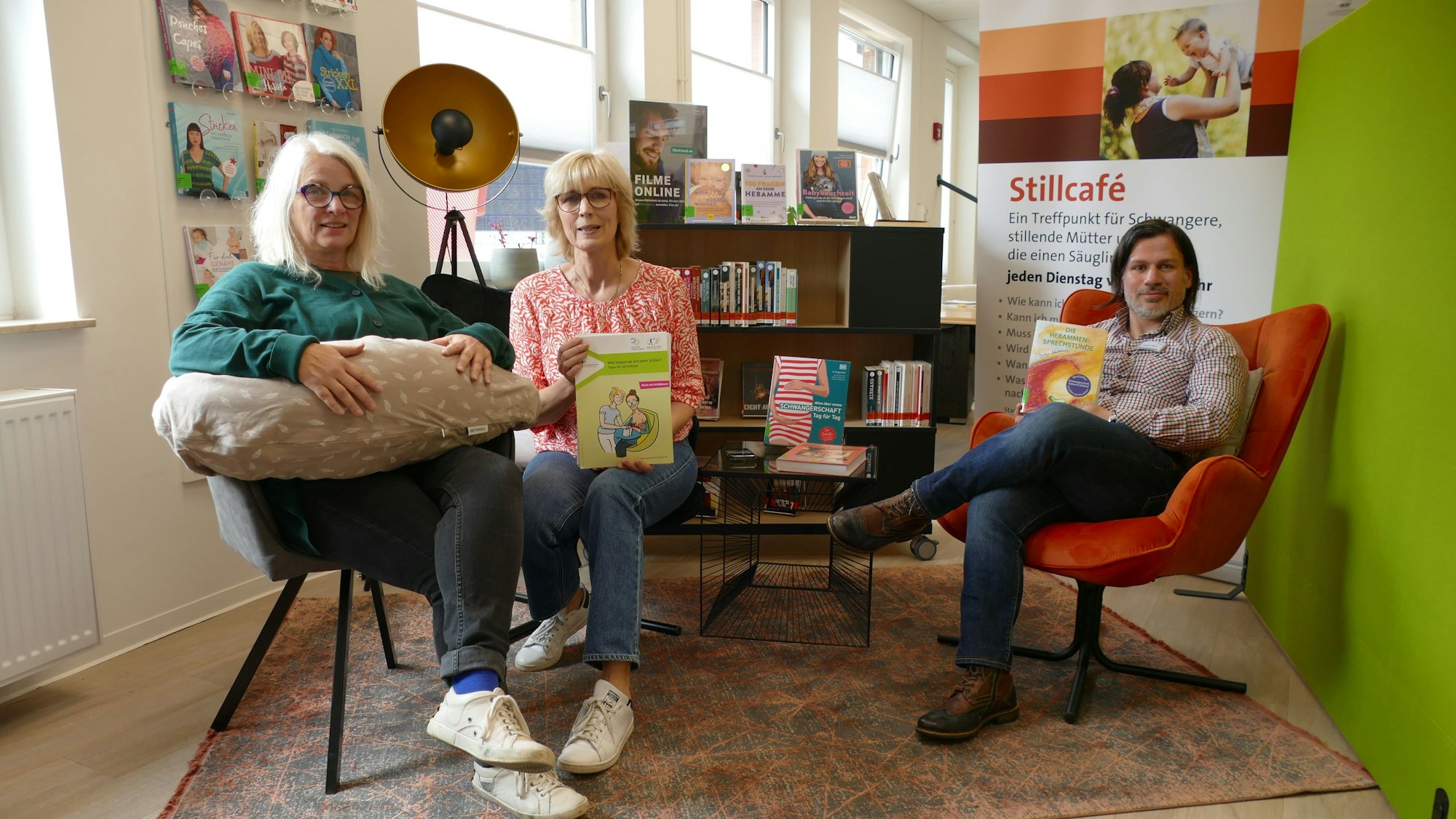 Drei Menschen sitzen auf Stühlen