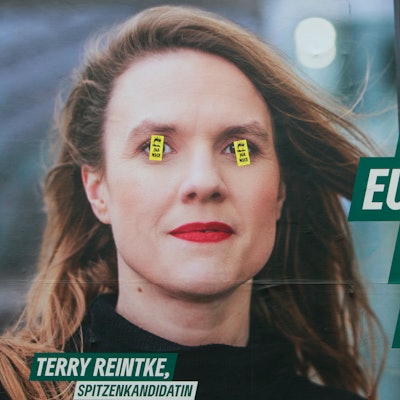 Ein Wahlplakat zur Europawahl von den Grünen am Ebertplatz ist mit Aufklebern teilweise überklebt.