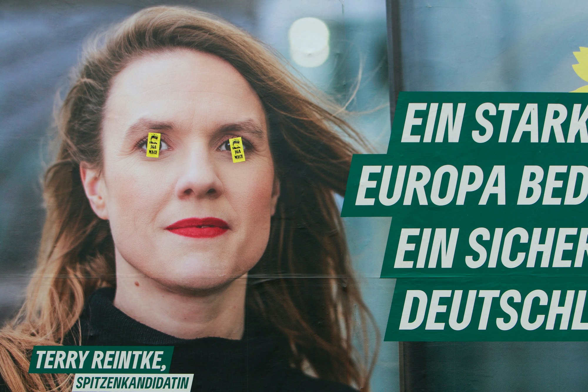 Ein Wahlplakat zur Europawahl von den Grünen am Ebertplatz ist mit Aufklebern teilweise überklebt.