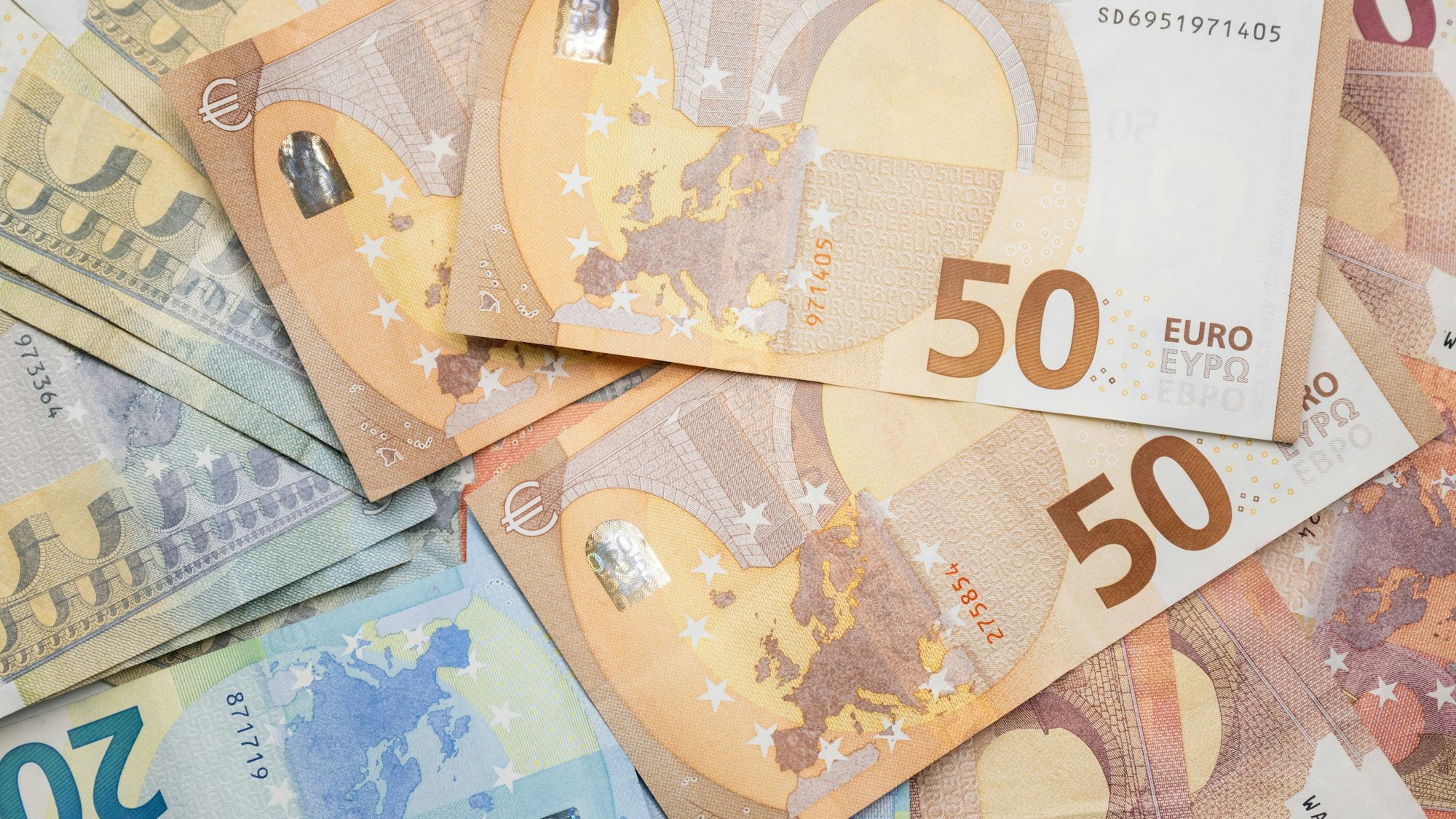 Zahlreiche Euro-Banknoten liegen auf einem Tisch.