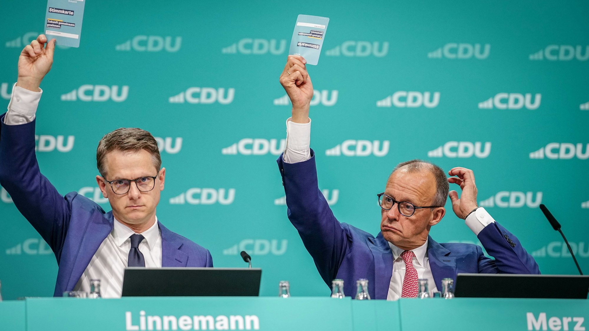 07.05.2024, Berlin: Friedrich Merz (CDU), CDU-Bundesvorsitzender und Unionsfraktionsvorsitzender, und Carsten Linnemann, CDU-Generalsekretär, heben die Stimmkarten zu einem Änderungsantrag zur Wehrpflicht beim CDU-Bundesparteitag.