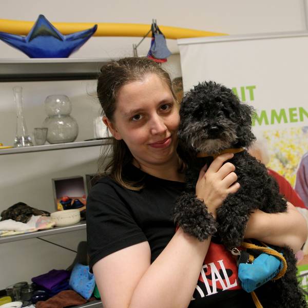 Eine Frau mit einem Hund auf dem Arm.