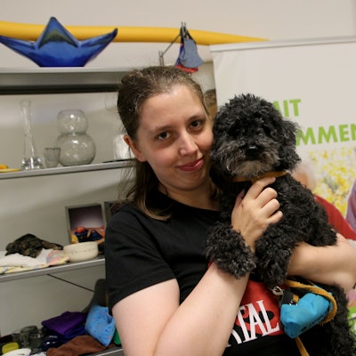 Eine Frau mit einem Hund auf dem Arm.