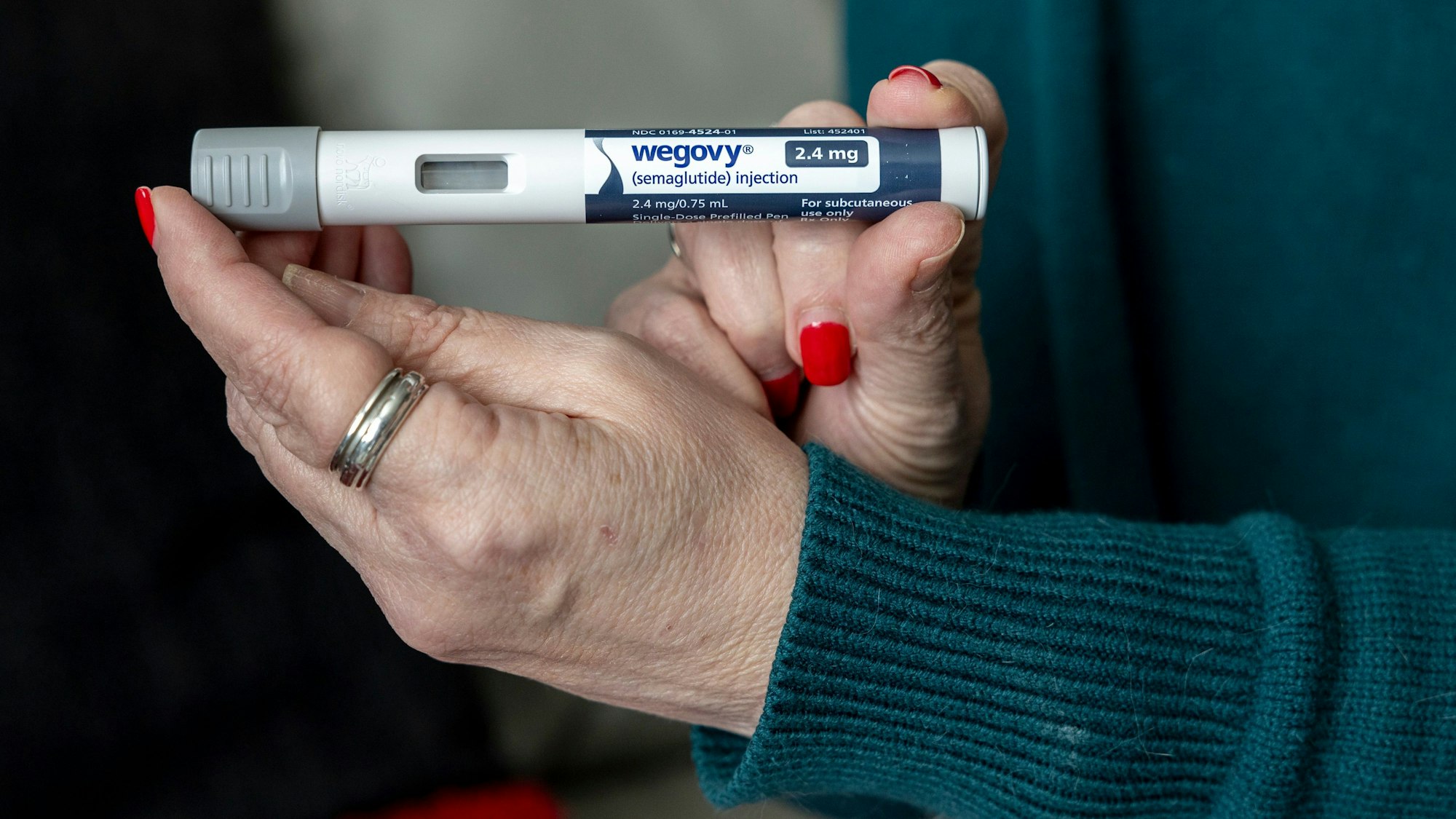 Eine ältere Frau hält die Abnehmspritze Wegoy in ihren Händen.