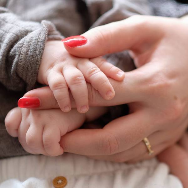 Eine Frau hält ein zwei Monate altes Baby im Arm.