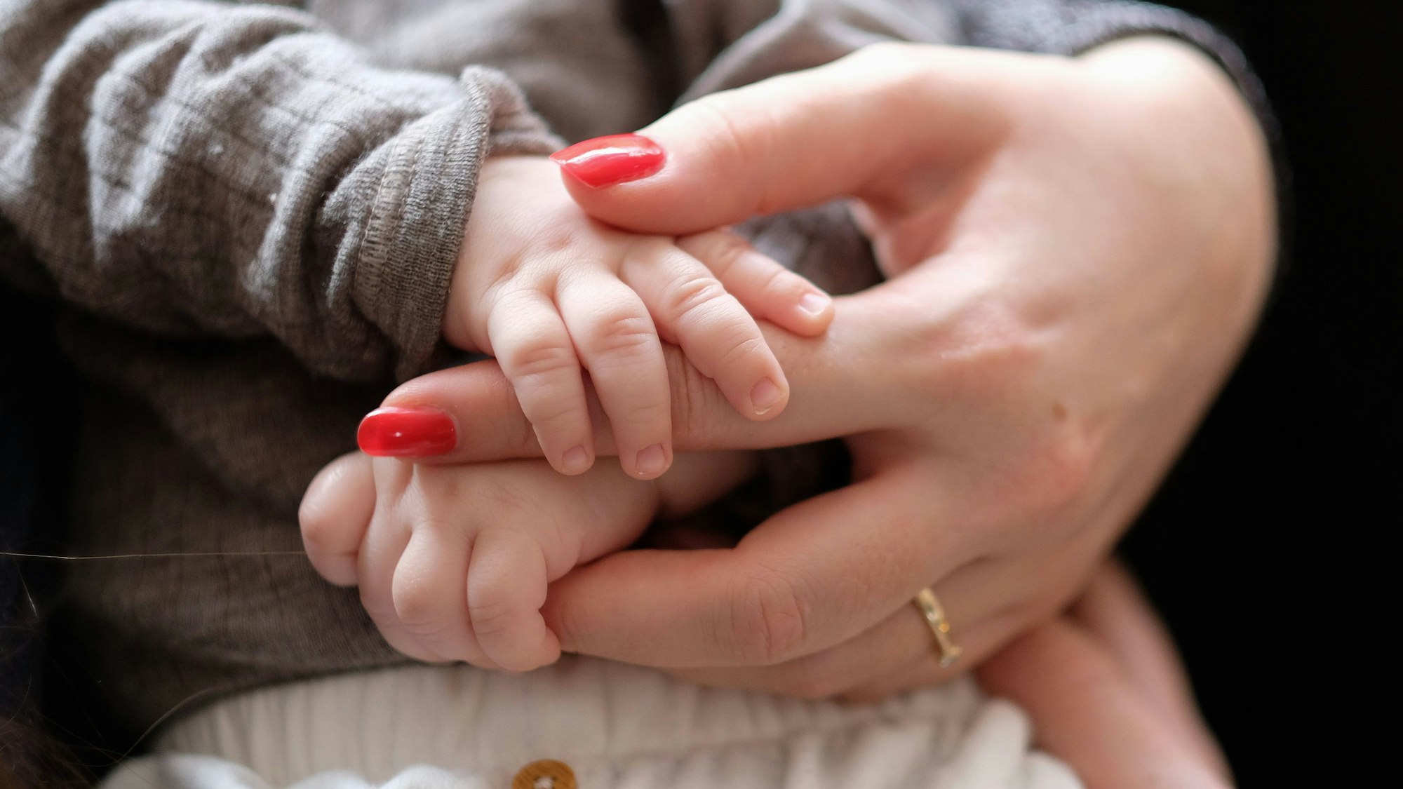 Eine Frau hält ein zwei Monate altes Baby im Arm.