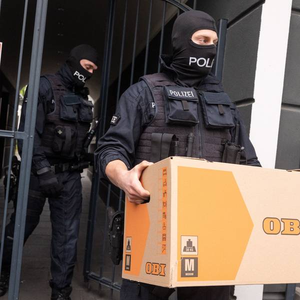 Ein Polizist trägt bei der Razzia gegen Schleuser am 18. April dieses Jahres einen Karton aus einem durchsuchten Gebäude.