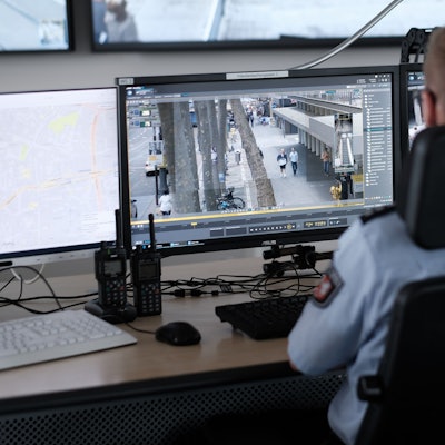 In der Video-Leitstelle im Kölner Polizeipräsidium sitzt ein Beamter vor einem Monitor, auf den Bilder einer Überwachungskamera übertragen werden.