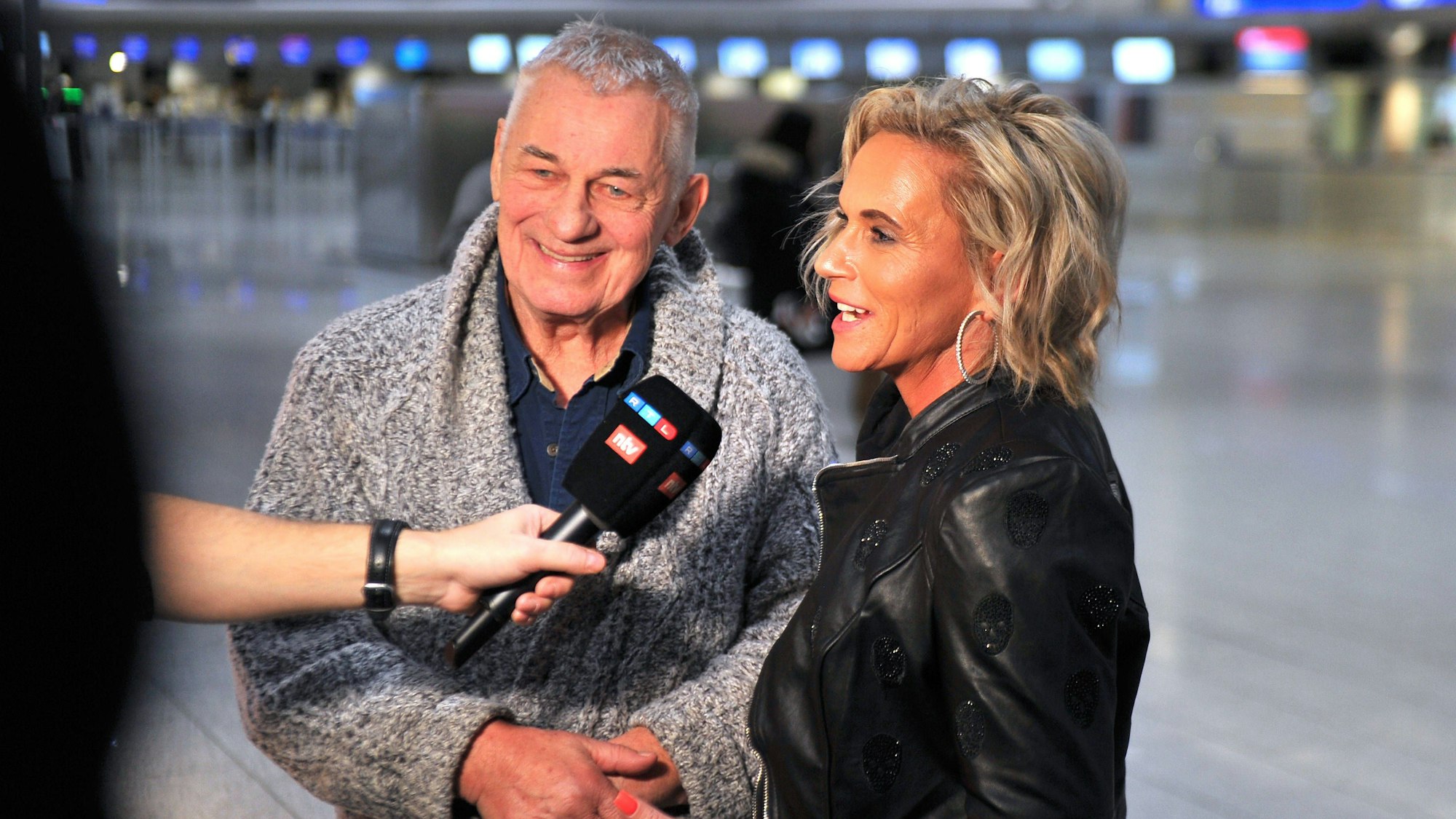 Heinz Hoenig gibt mit seiner Frau Annika Kärsten-Hoenig ein Interview am Flughafen.