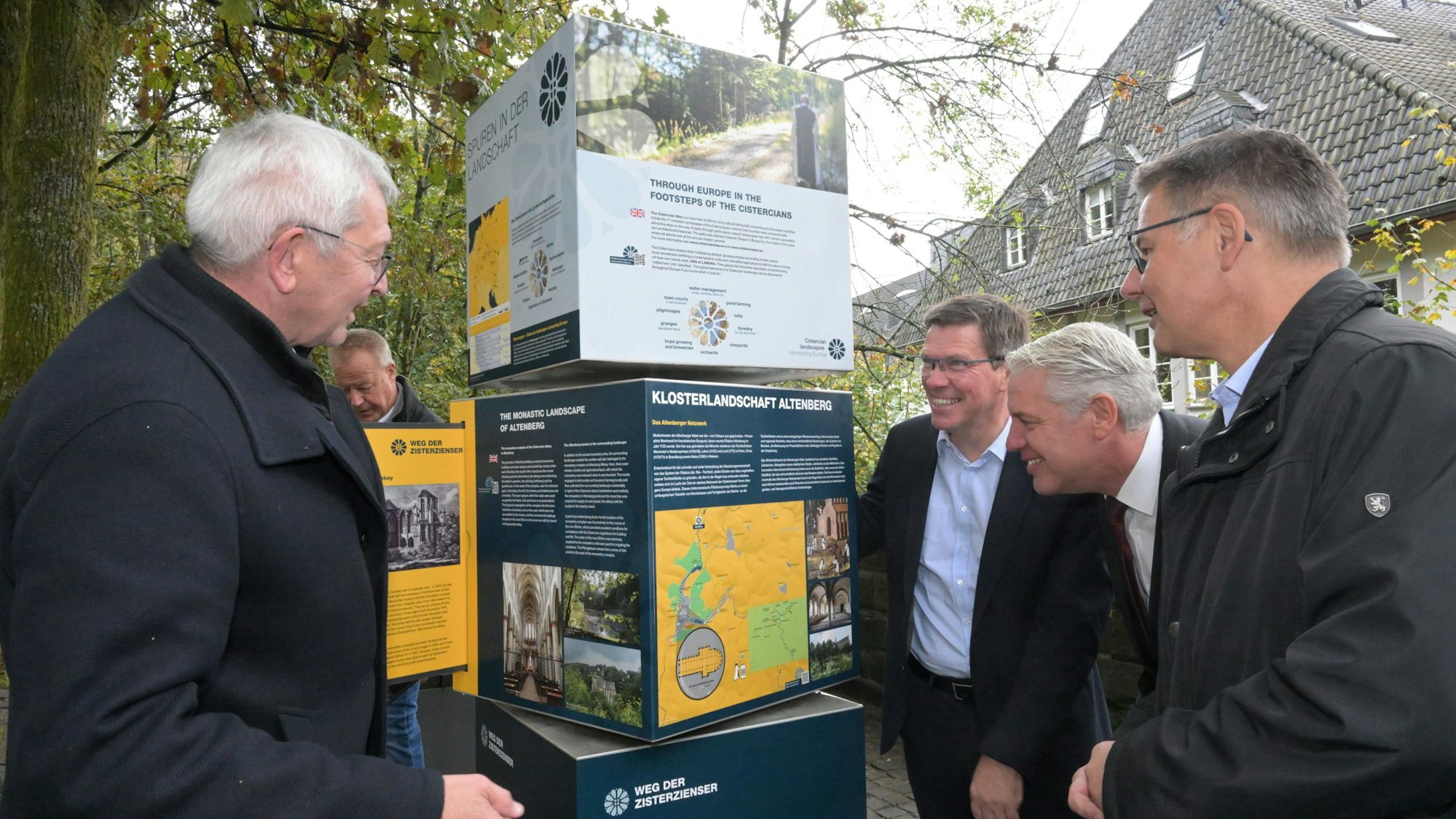 Vier Männer stehen an einer Informationsstele, die über den Pilgerweg der Zisterzienser informiert.