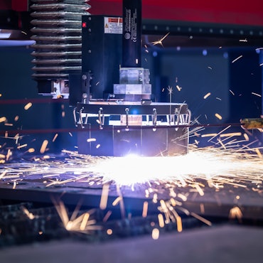 Ein Plasmaschneider schneidet in einem Stahlhandel aus einem Grobblech Teile aus.