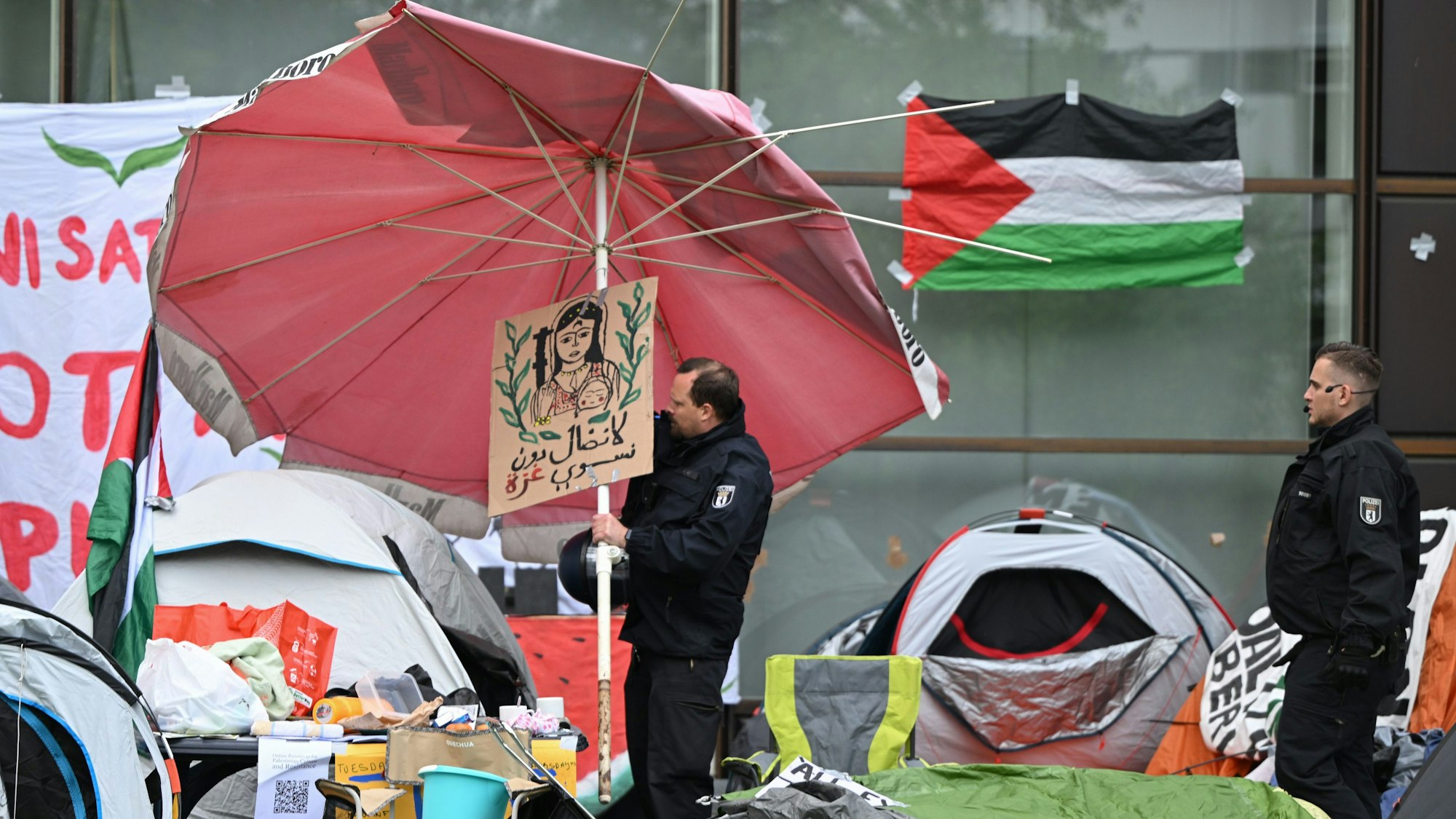 Polizeibeamte räumen am 7. Mai nach der Räumung einer pro-palästinensischen Demonstration der Gruppe „Student Coalition Berlin“ auf dem Theaterhof der Freien Universität Berlin das Camp ab.