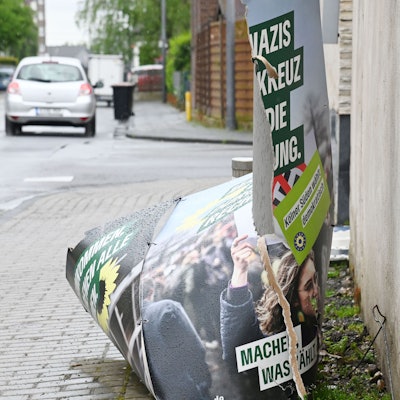 Ein zerstörtes Wahlplakat liegt auf dem Boden.