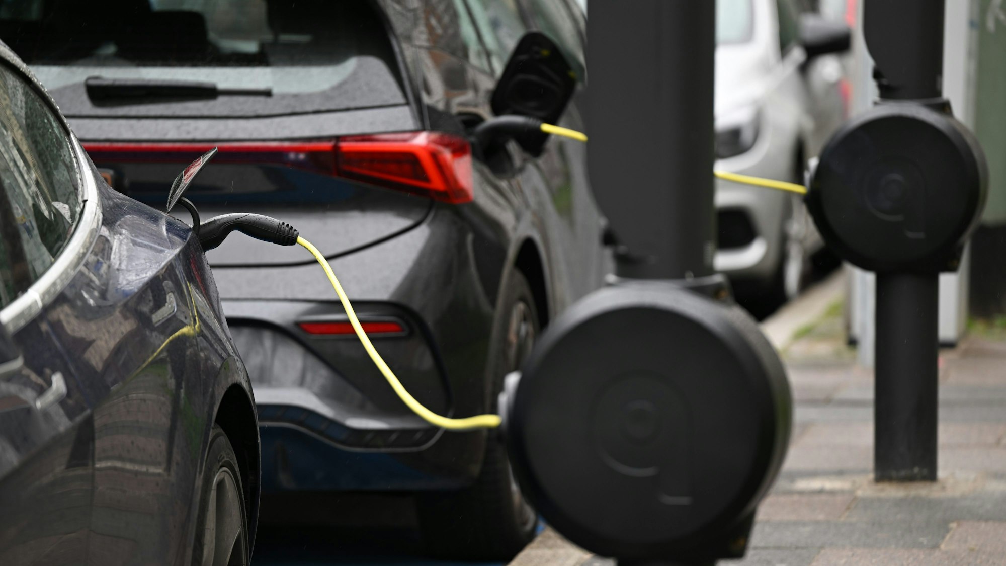 E-Autos stehen in der Innenstadt an E-Ladesäulen.